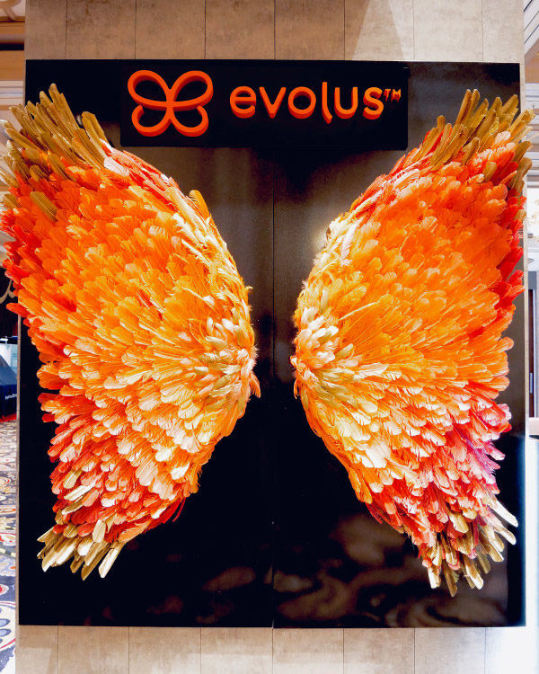 evolus-brand-activation-trade-show-booth-butterfly-wings-orange-feathers-fgpg-experiential-600x750