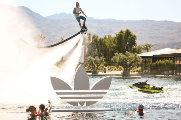 man on a hydro jet above a pool with an adidas sign