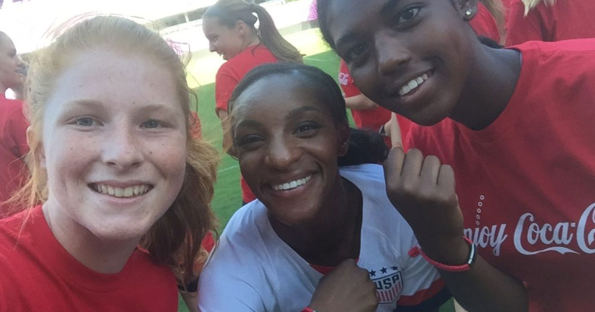 young girls posing with a member of the us women's soccer team for brand activations