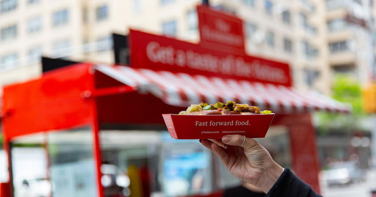 hand holding a fast food dish of upscale hot dogs for brand activations