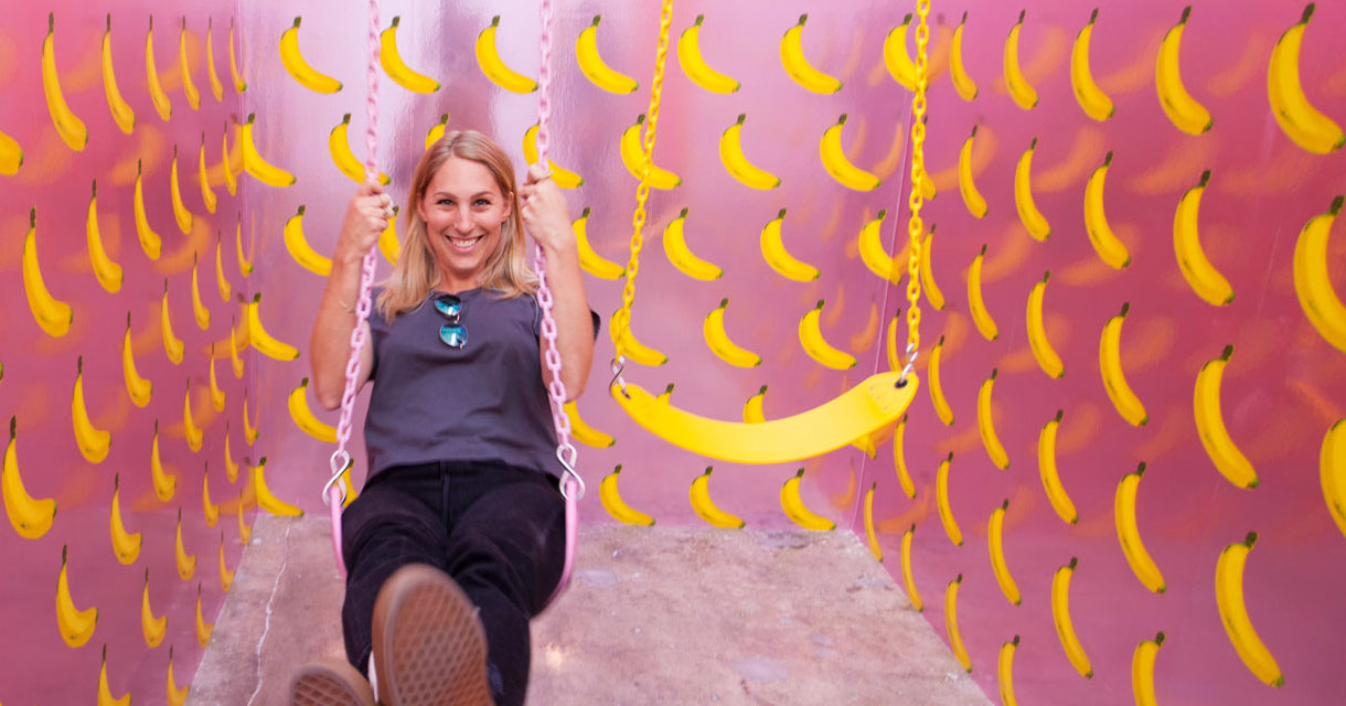 woman swinging on a banana swing in the ice cream museum