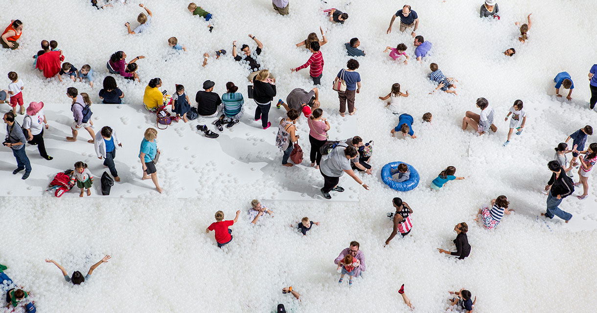people playing in a large playpen of white balls for Instagram Museums