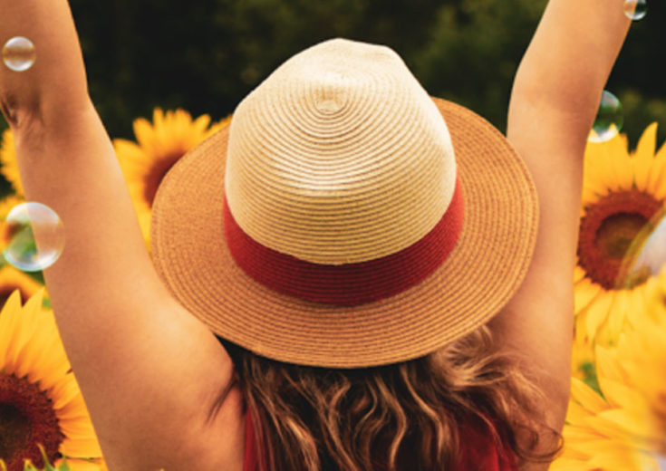 girl in sunhat with surrounded by bubbles and sunflowers for brand activations