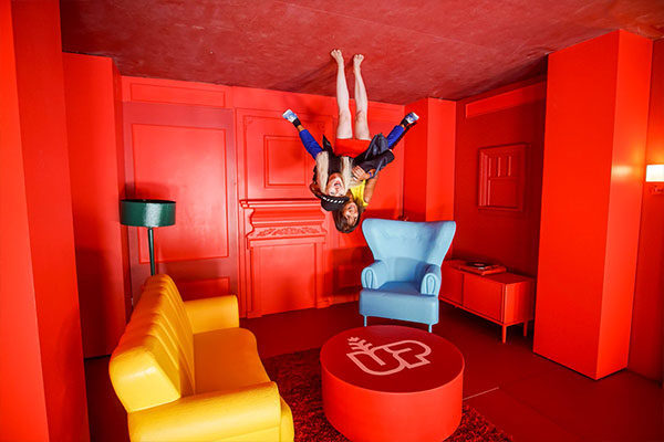 upside down house pop-up experience people on ceiling in a red room