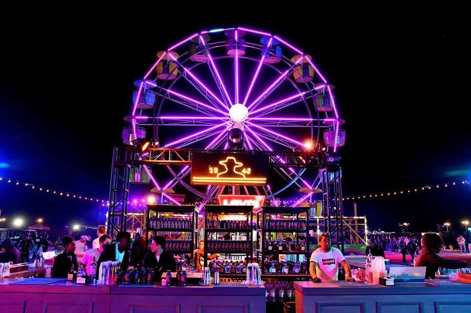 Coachella 2022 Don Julio Brand Activation with bar in front and ferris wheel with neone lights in the background